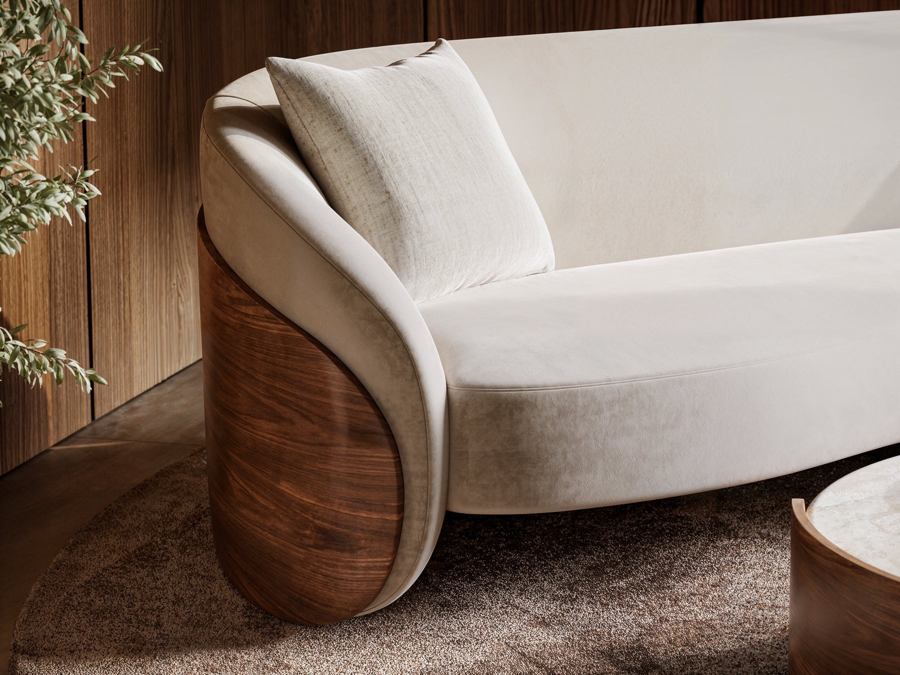 A close-up of ivory upholstery and a beautifully curved walnut sofa frame